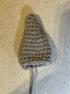 a knitted cone shaped object on a white surface