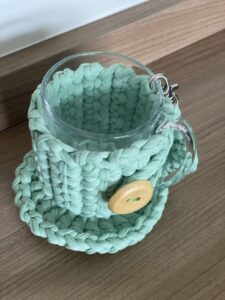 a glass cup with a knitted cover