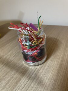 a jar of colorful threads